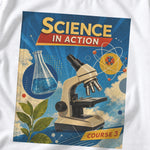 White Science Textbook tee with a blue "Science in Action" graphic featuring a microscope, flask and atom.